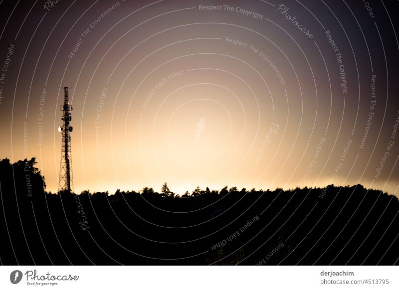 A bright silhouette glow, behind the background with the Great Antenna standing next to it. The sunset has set and bathes the land in a bright glow. Sunset Sky
