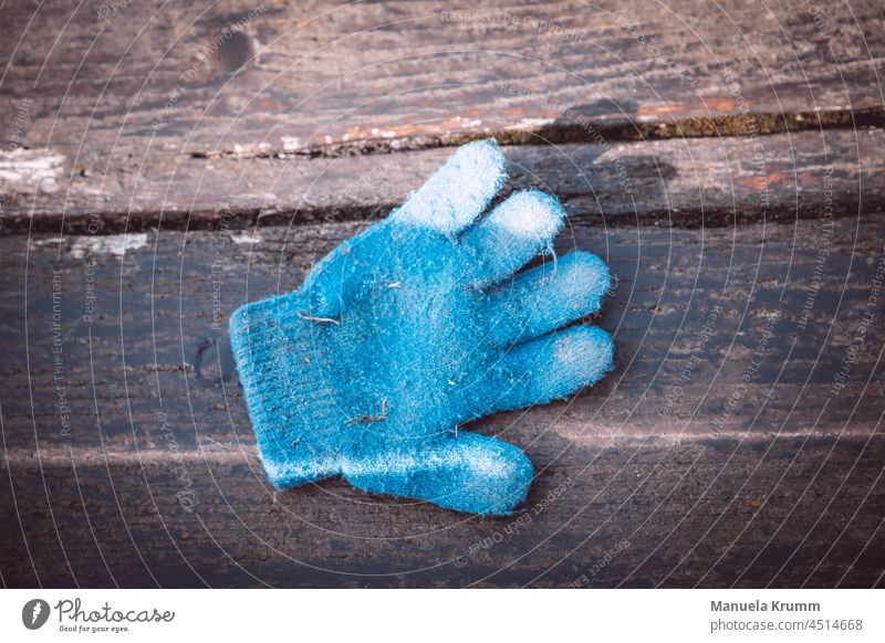 Glove on a bench Gloves Individual Blue Deserted Exterior shot Colour photo Brown Bench Light Shadow Wooden board Wood grain Contrast Structures and shapes