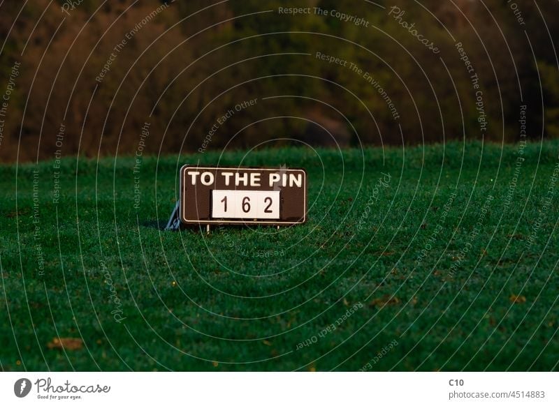 To the pin sign at a golf course close closest club country dew fairway game goal golfer golfing grass green hobby landscape leisure measuring morning outdoor