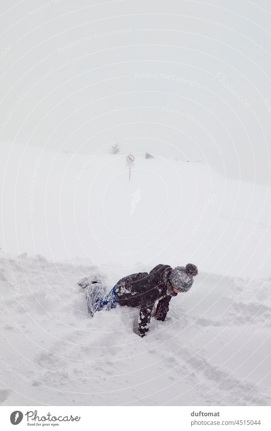 Child playing in snow on ski slope in fog weather Snow Deep snow Peak Winter Mountain Weather Snowcapped peak Alps Landscape Cold fun Freeze Christmas