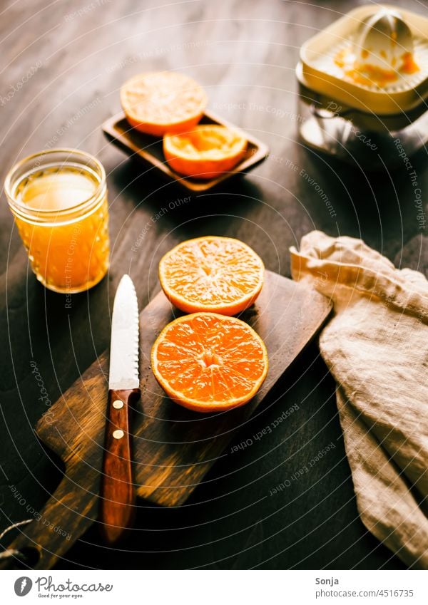 Frisch gepresster Orangensaft auf einem Holztisch in der Morgensonne orangensaft trinkglas saftpresse schneidebrett Frühstück Food photograph Healthy Nutrition