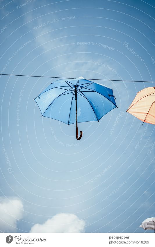 Umbrellas attached to a rope at an airy height Flying Floating Blue Blue sky Blue background Sky Beautiful weather Exterior shot Colour photo Worm's-eye view