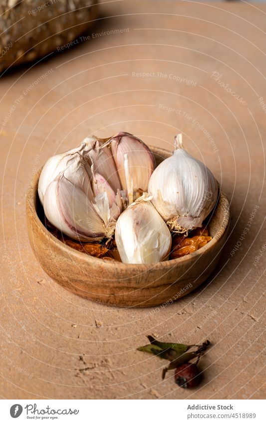 Cloves of garlic on table clove bulbous allium unpeeled aromatic kitchen product flavor husk natural healthy fresh organic raw nutrient uncooked wooden pile