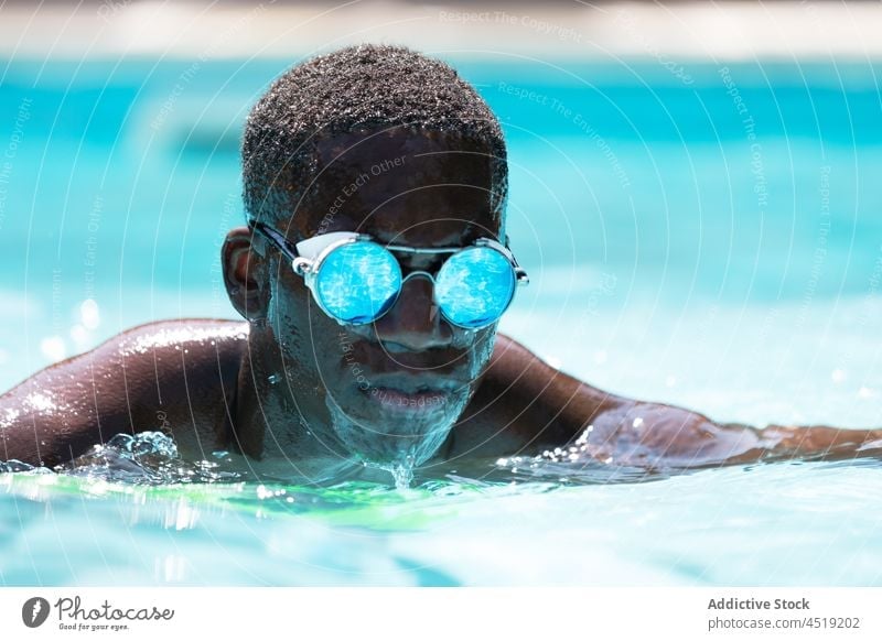 Black man in swimming pool sunglasses rest water leisure pastime recreation summer black male chill sunlight color sunshine summertime guy african american wet
