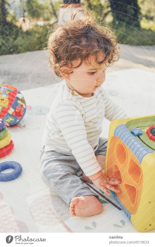 Little baby enjoying the day playing with her toys playful babyhood parenthood toddler happy happiness kindergarten outdoors nature natural candid real people