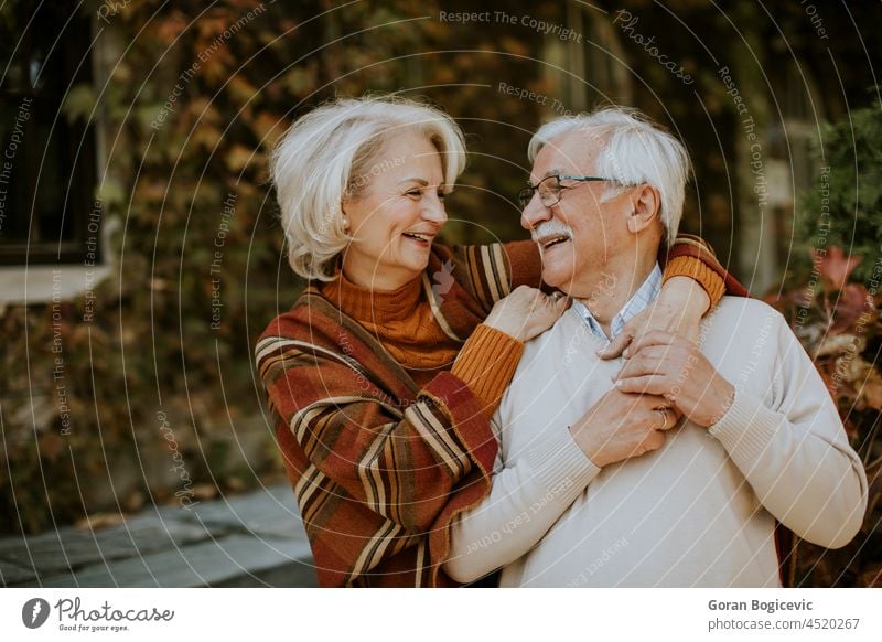 Senior couple embracing in autumn park old senior love woman smiling husband retired wife outdoors romance mature casual relationship people elderly happy