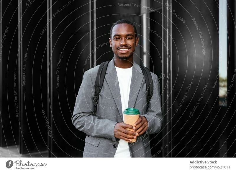 Smiling black man with takeaway coffee executive disposable positive formal style well dressed appearance male toothy smile cup businessman glad carefree