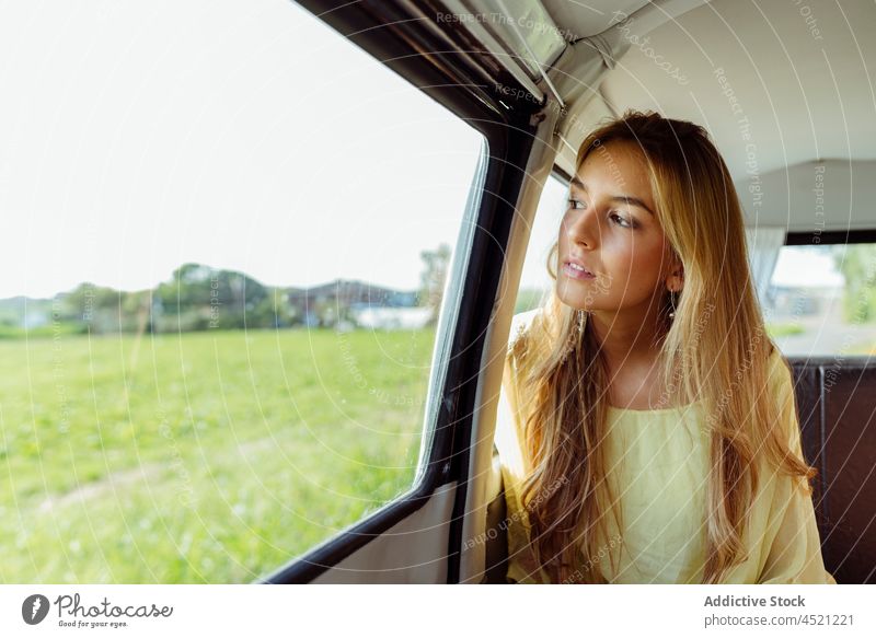 Pretty blonde girl inside a van looking through the window young woman female youth caucasian caravan summer travel summertime leisure holidays colorful