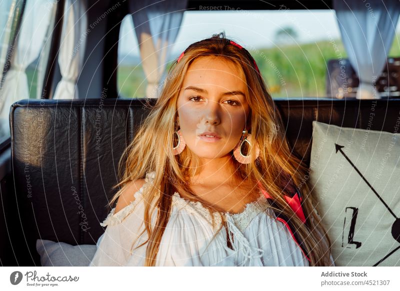 Attractive blonde girl inside a vintage van and lying on the seat on a sunny day attractive sensual pretty woman female caucasian sitting relaxed