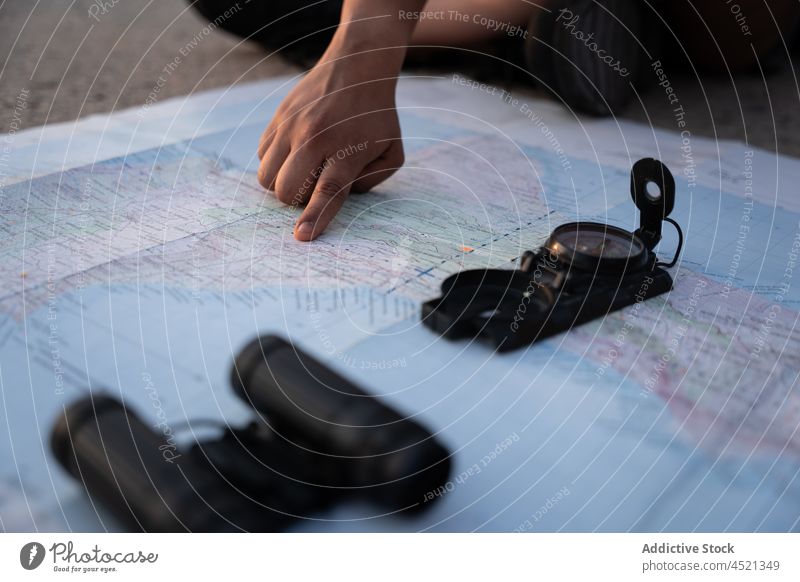 Black woman pointing at location on map traveler guide navigate search compass check direction orientate female trip tourist explore route find discovery