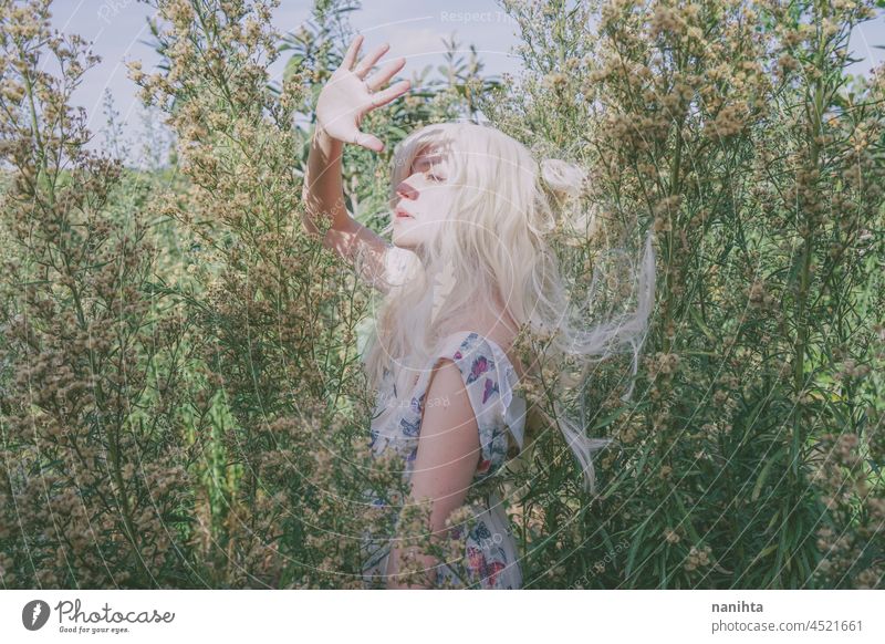Artistic and reamy portrait of a woman surrouded by nature forest fantasy fairy delicate albino fairy tale feminine femininity long hair white caucasian pale