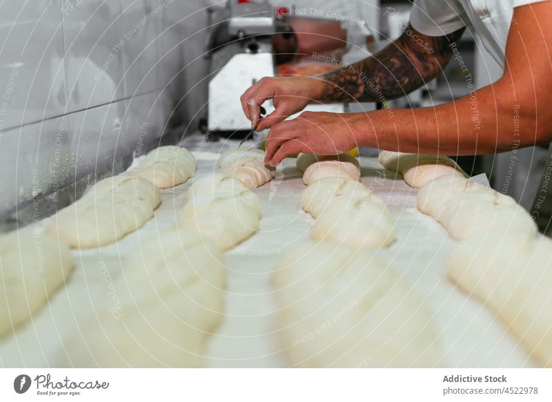Baker preparing bread in kitchen man prepare chef scoring bakery food culinary cook professional blade work male bakehouse job cuisine pastry baked tasty