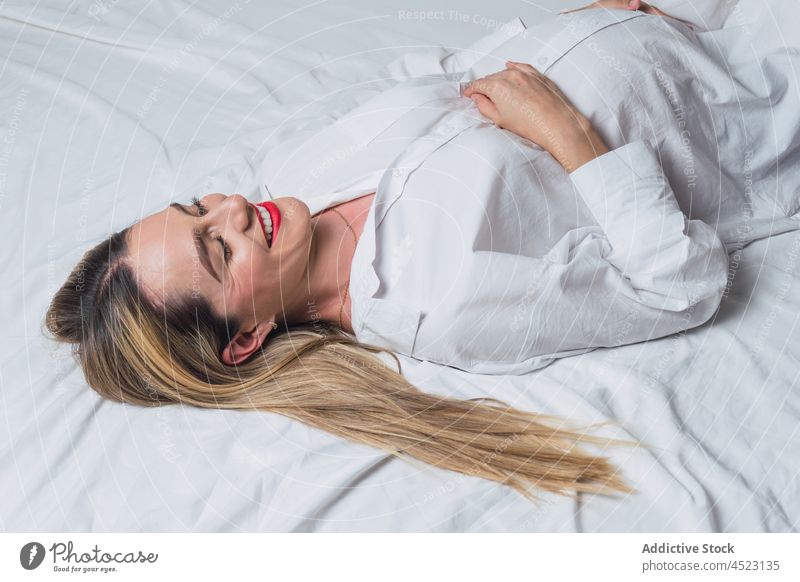 Positive pregnant woman with hand on belly lying down on bed tender gentle maternal harmony positive anticipate expect female pregnancy smile carefree pleasure