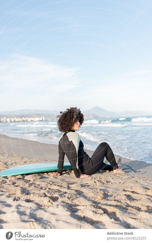 Woman in wetsuit with surfboard lying on sandy beach woman surfer sea wave seascape harmony tropical female shore coast relax exotic clear seashore barefoot