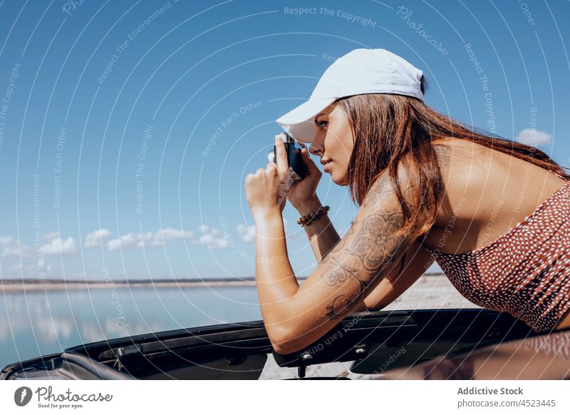 Young woman taking photo on vintage camera photo camera take photo capture car coast old fashioned pond nature female transport environment lake old timer
