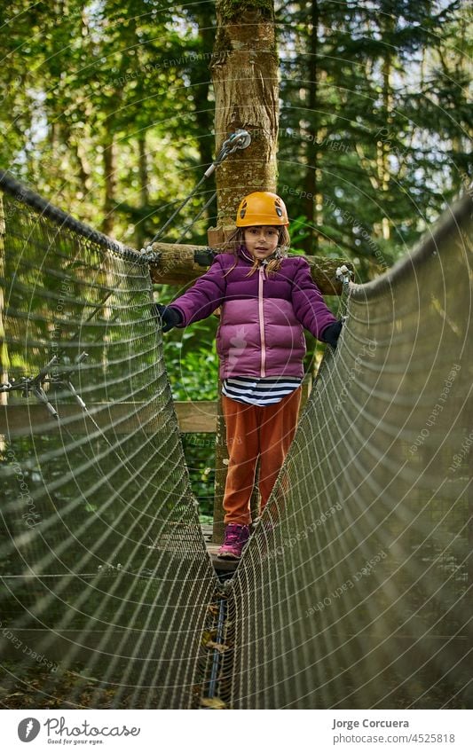 adventure climbing high wire park - kids on course in mountain helmet and safety equipment people young child action leisure brave fun joy nature play tree