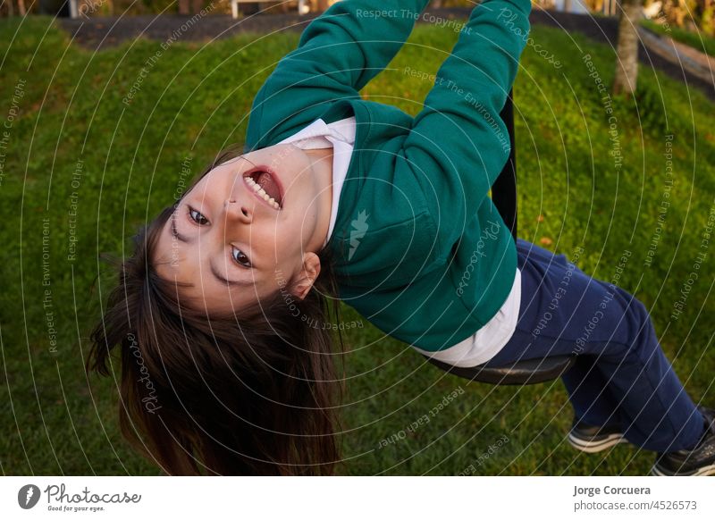 overhead shot of a five-year-old girl in a school uniform hanging from a rope playground fly riding walk kid cute outdoor happy young park child fun outside