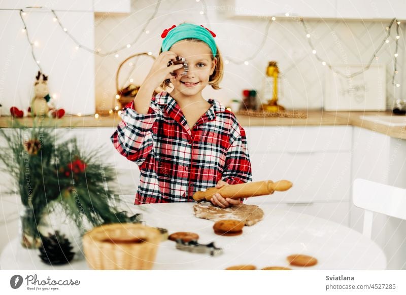 A girl in a plaid shirt bakes Christmas cookies on Christmas Eve or New Year's Eve christmas christmas cookies new year cookies advent holiday happy home