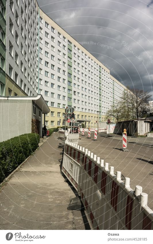 Road construction in front of a sunny prefabricated building facade under an overcast sky Building Prefab construction Facade Window residential building Street