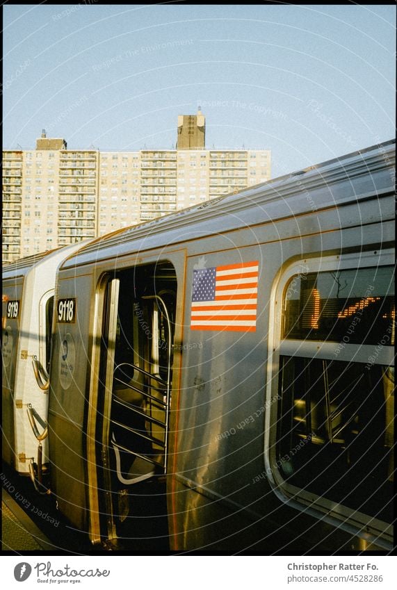 Stomming view of a New Yoker subway with US flag near Conny Island. Brooklyn, New York. Filmlook Tourism Twilight Light warm Federal elections Tourist Sky