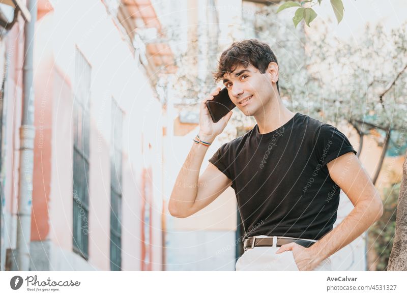 Young urban man making a call while smiling, copy space, next rental bikes in the city, modern transport, city lifestyle, young life in the city, lgbt men blank