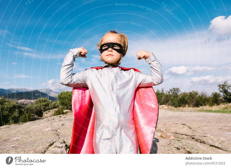 Brave superhero in costume showing muscles girl fist strong posture brave courage rescue power protect strength confident inspiration landscape defense cloak