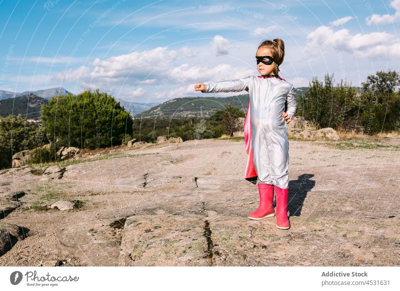 Brave kid in superhero costume showing fists girl child strong power courage pretend fearless gesture hill cape brave childhood strength protect cloak little
