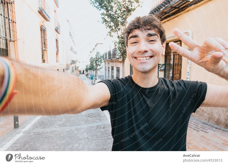 Young man taking a selfie smiling to camera in in the city of madrid with modern styling with copy space, City life style, modern attitude. Copy space person
