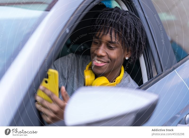 Black male driver talking on smartphone in car man open using street style cool phone call communicate connection device headphones transport listen cellphone