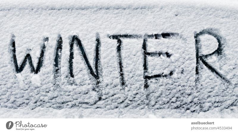 winter written in snow on car window word text cold weather writing temperature season ice white message fresh frost write closeup meteorology finger nobody