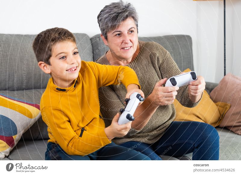 Little kid and his grandmother playing video games age generation blur boy caucasian child competition console electronic elementary age emotion entertainment
