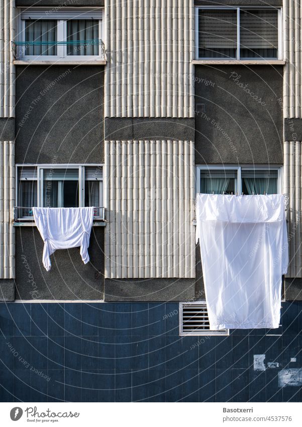 Washing day in a working-class neighborhood, laundry hanging to dry on the windows of a prefab housing development. Sansomendi district, Vitoria, Basque Country, Spain