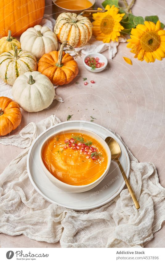 Pumpkin soup near sunflowers in kitchen pumpkin carrot vegetable healthy food dish pomegranate meal vitamin plant seed natural various fresh ripe bowl serve