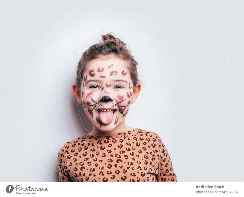 Happy girl in cheetah costume kid childhood paint spot carefree grimace playful positive cute smile cheerful content creative light make face joy appearance