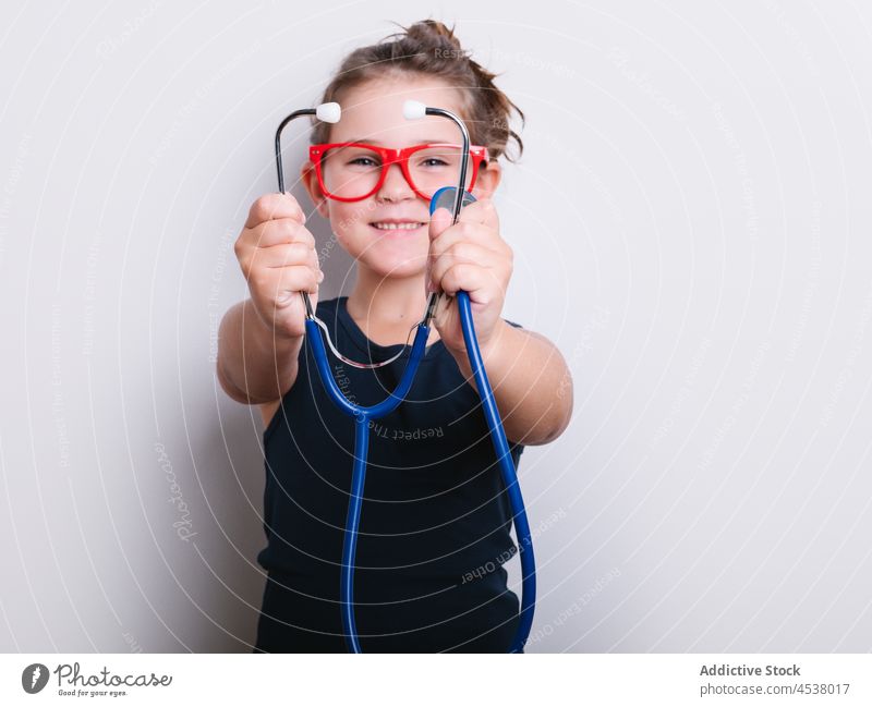 Cheerful girl in doctor outfit stethoscope disguise play medical playful childhood instrument cheerful happy positive studio eyeglasses medicine adorable