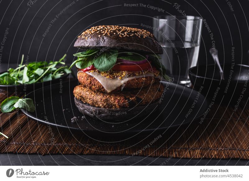 Delicious burger on plate near glass of water sesame food salad delicious vegetarian fast food appetizing tasty leaf fresh portion nutrition yummy seed dish
