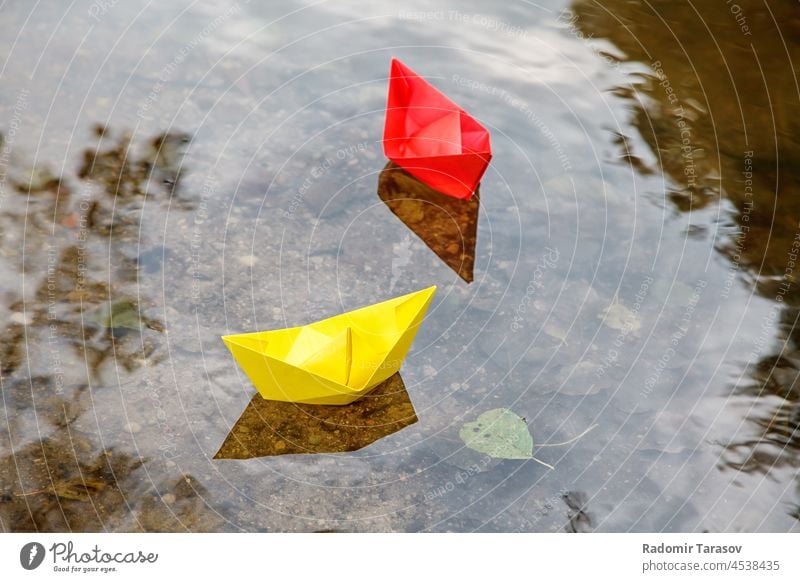 two multicolored paper boats floating on a stream origami ship outdoors season park river small nature cute female little fun together creative water concepts