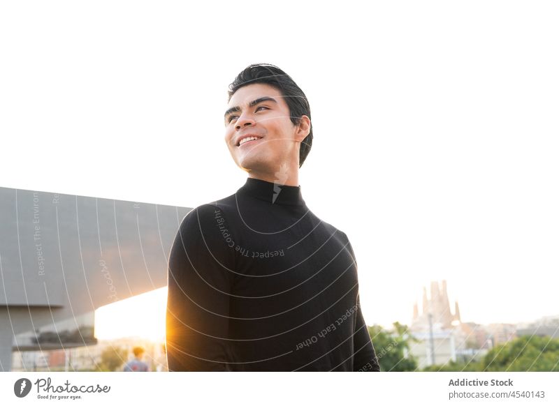 Serious Asian man on sunny street building smile city style urban modern appearance happy sunlight outfit delight asian ethnic glad apparel trendy male
