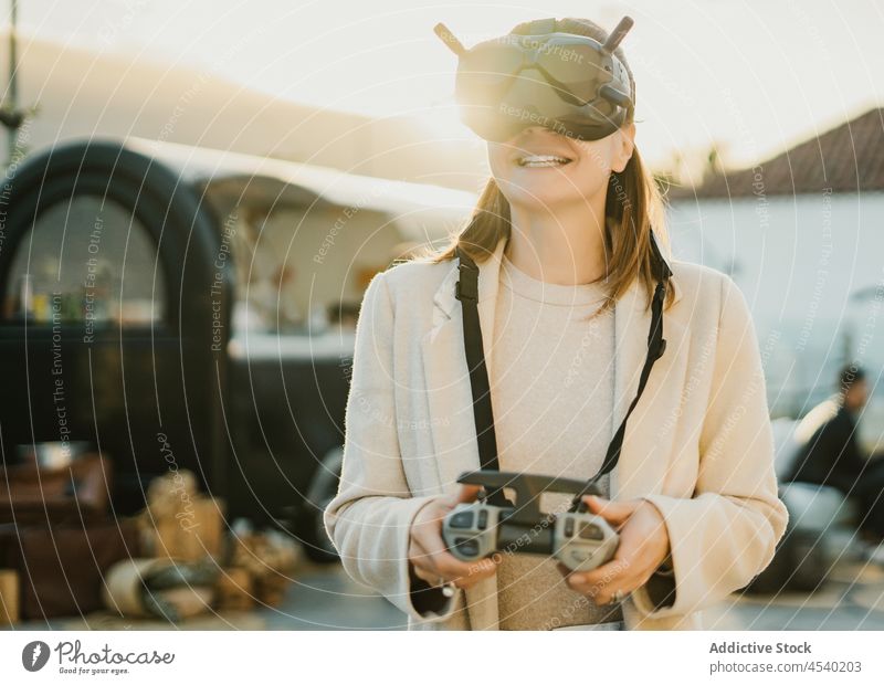 Unrecognizable woman in VR goggles controlling drone vr remote control headset virtual reality immerse technology uav cyberspace experience innovation street