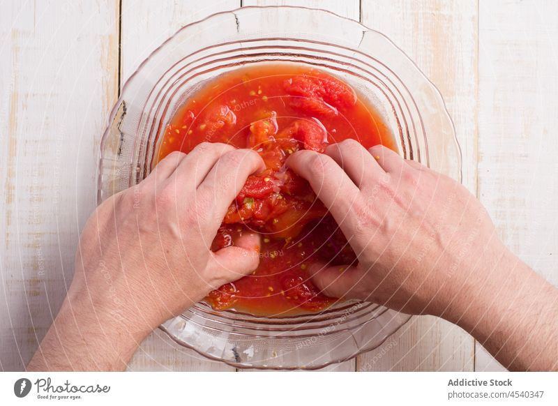 Anonymous person mashing tomatoes in bowl cook squash marinara sauce cuisine food culinary prepare fresh delicious yummy kitchen ingredient product hand process