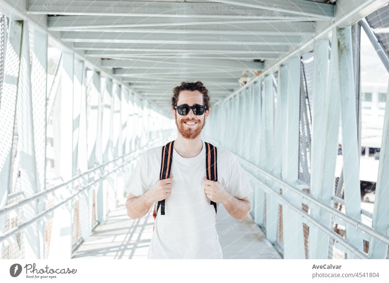 Portrait of a young man at the airport or bus station , luggage, bags and suitcase. Smiling hipster traveler with sunglasses, copy space, sunny day baggage