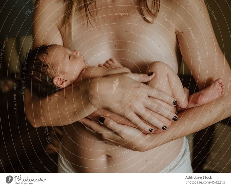 Anonymous mother hugging baby woman embrace newborn breastfeed love naked together motherhood childhood nude female young home cute adorable affection calm mom