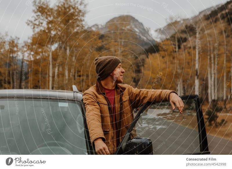 Man in the mountains in the fall leaning out of car on door aspens Aspen Colorado fall foliage Fall Travel Adventure Adventurer Birch Yellow Mountains