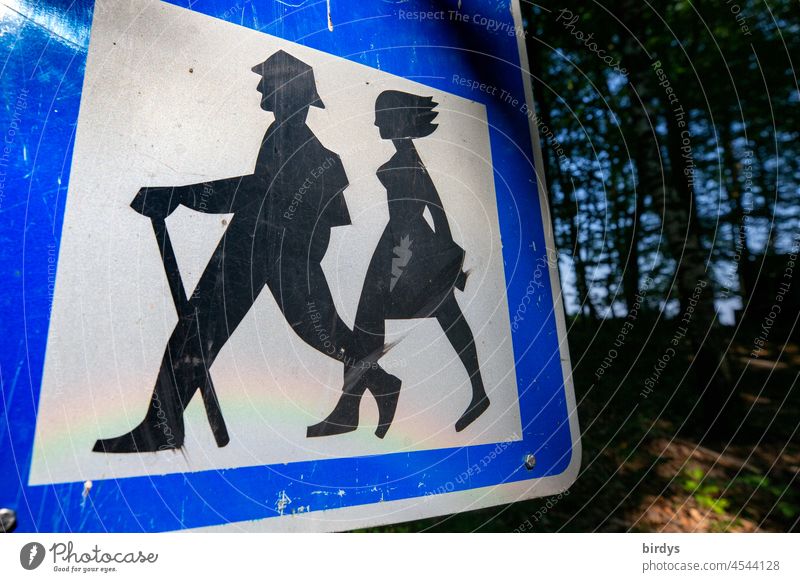 Non-gender appropriate depiction of an old hiking sign with a man in front and a woman following behind Couple hetero Man Woman Adults Gender equality