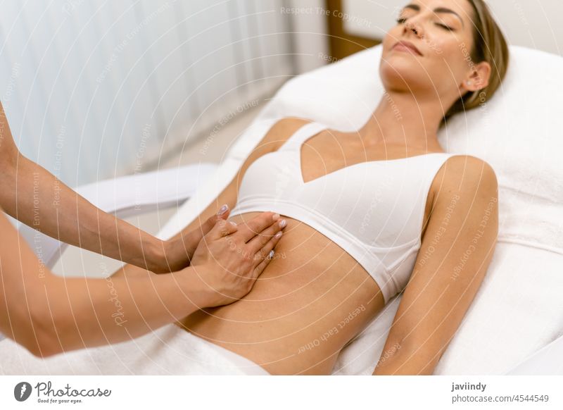 Middle-aged woman having a belly massage in a beauty salon. abdomen people female spa body relax massaging masseur wellbeing treatment care therapy wellness