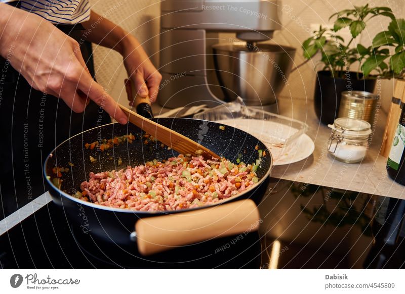 Woman cooking sauce bolognese in kitchen pan woman ragu ingredient preparing female stove healthy spoon pot hot house italian meat onion lunch spaghetti meal
