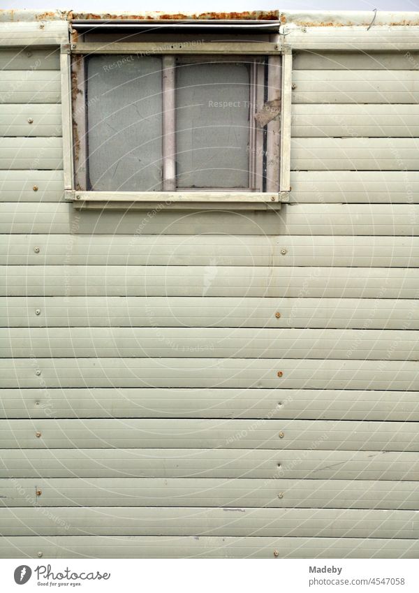 Wooden panel with window of an old construction trailer as changing room in summer at the beach in the bay of Alacati near Cesme at the Aegean Sea in the province of Izmir in Turkey