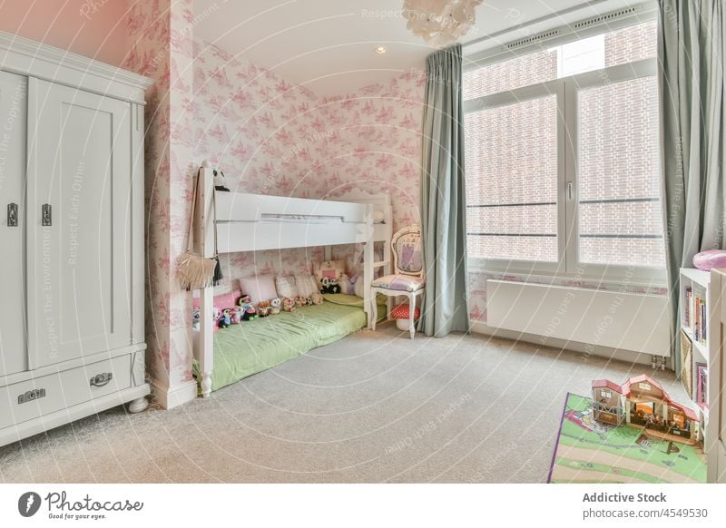 Interior of kid bedroom with pink walls and wooden furniture girl apartment design residential window wardrobe flat cupboard toy comfort style curtain closet