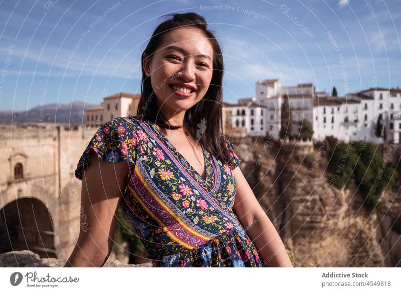 Glad Asian woman sitting near historic bridge in Ronda travel ancient old cliff mountain nature tourist aged architecture sightseeing tourism summer vacation