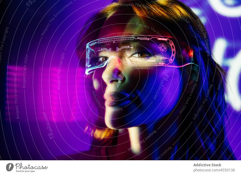 Woman In Neon Lights with Led Glasses futuristic metaverse accessory augmented reality blur videogame headshot woman bright eyeglasses modern device
